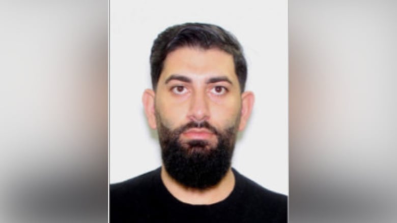 A man with a black shirt and a black beard