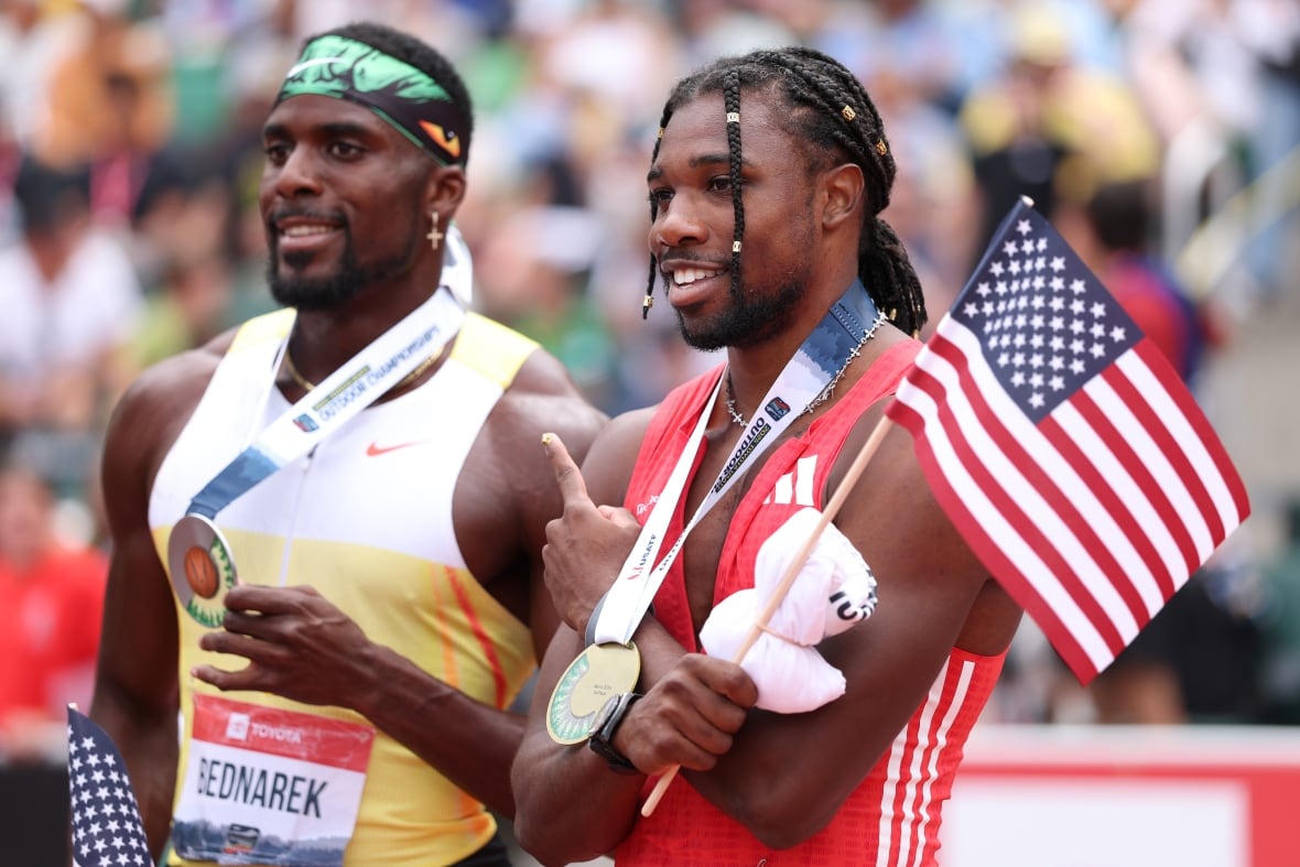 Two runners display their medals.