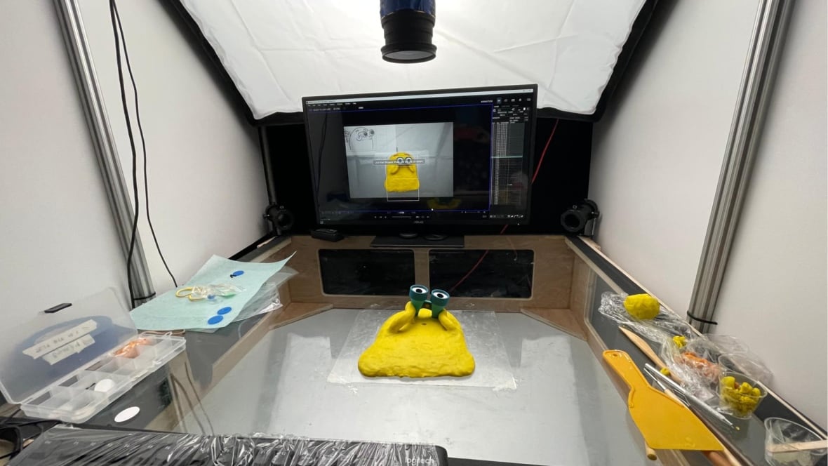 A view of a plasticine character laid out on a sheet of glass with a camera overhead.  