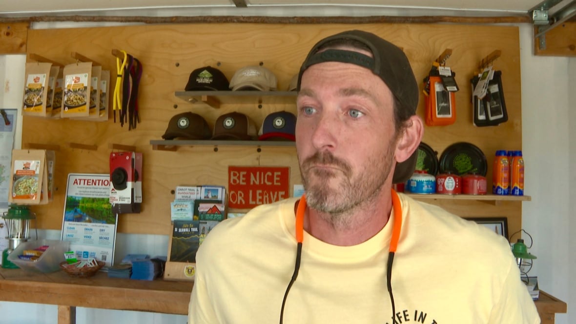 A man with a backwards hat and a yellow t shirt.