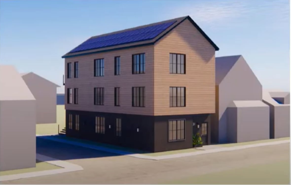Three-story building at a street corner with solar panels on the roof