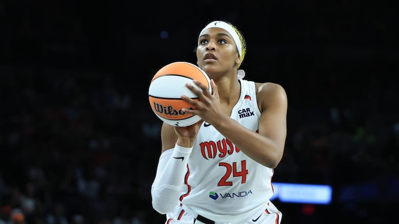 A woman shoots a basketball.