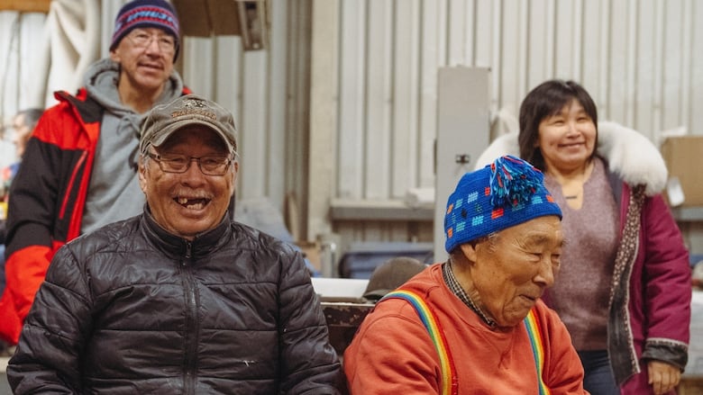 two elders sit in the front, two other elders stand at the back. the four people are smiling.