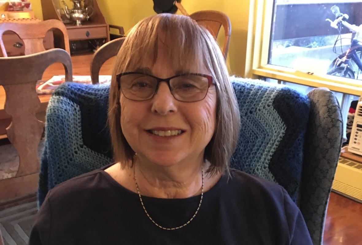 Woman sits on chair smiling