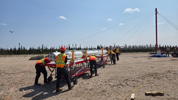 A Concordia University student team is preparing to launch the first Canadian rocket to enter space in over two decades—right from Cree territory near Mistissini, Quebec. A group of people carrying a body of metal to a rocket tour.