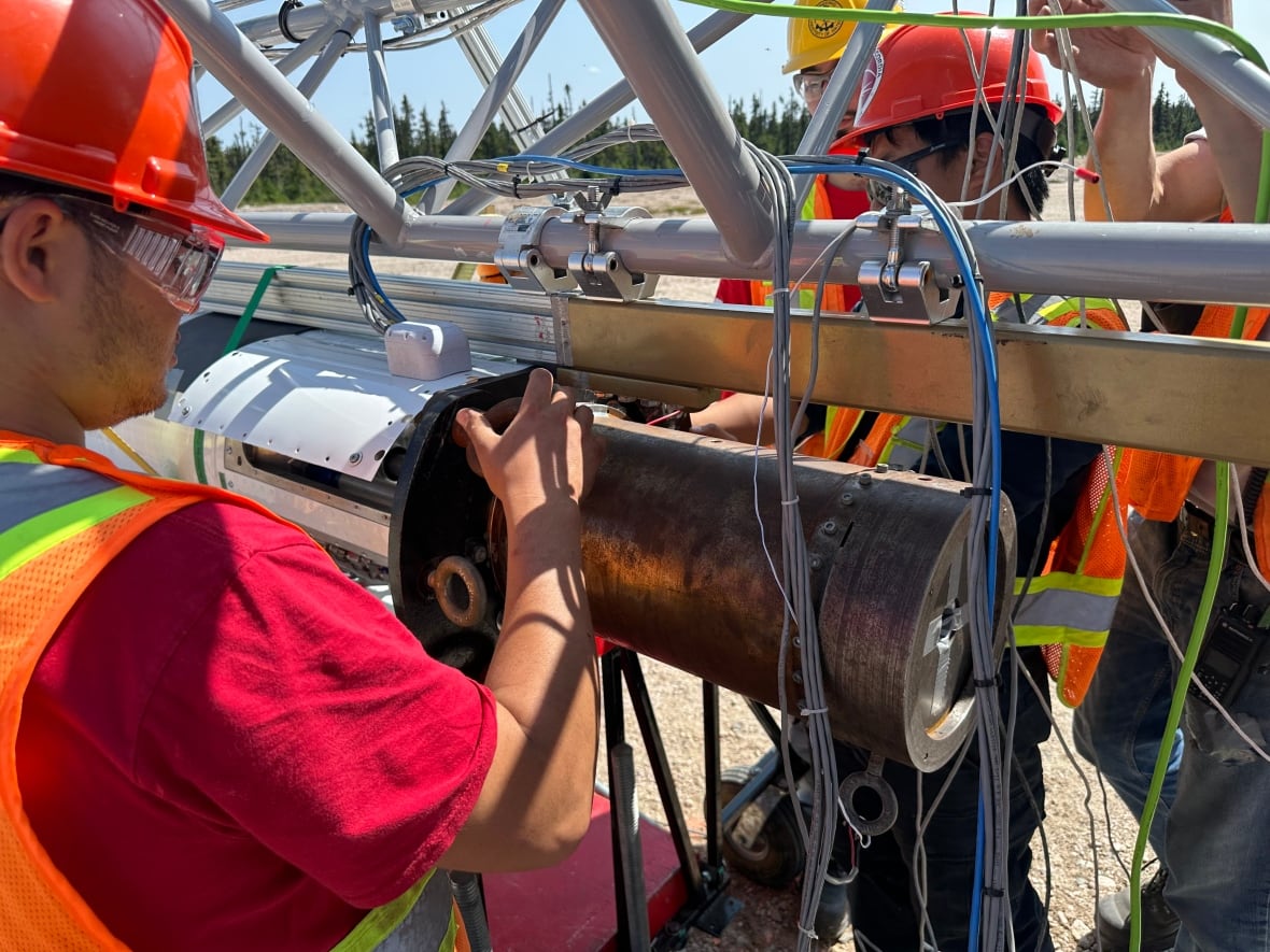 A group of people assembling a rocket tower. 