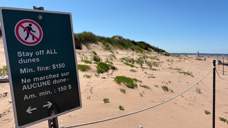 A beach sign that reads "Stay off ALL dunes - Min. fine: $150"