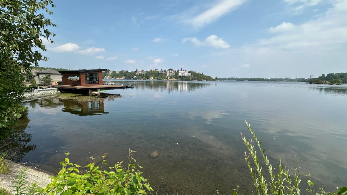 A lake with some large buildings on the far shore.