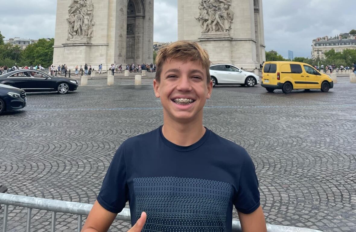 A teenage boy smiles outside