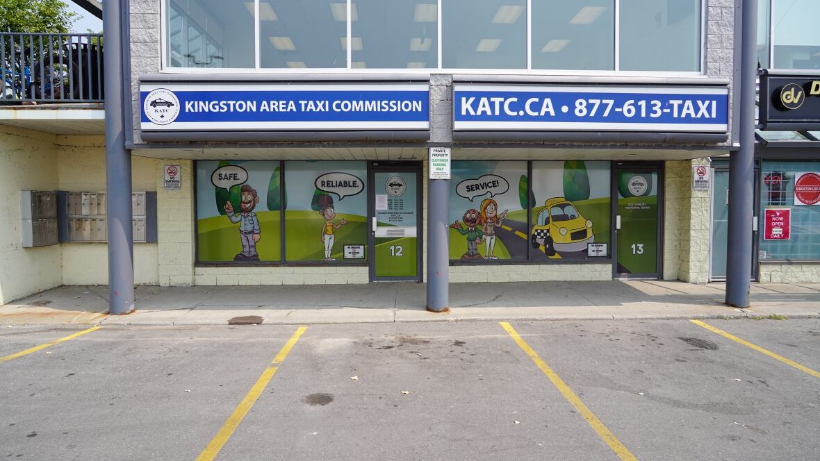 A building with windows covered in cartoon images of cabs is shown on a sunny day.