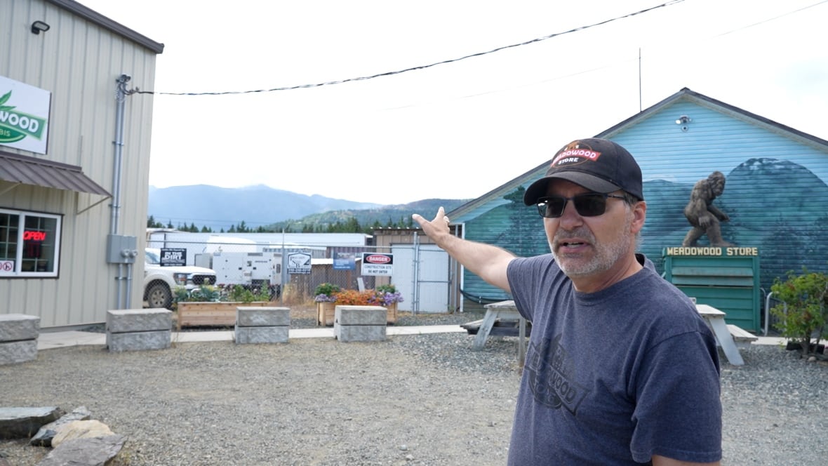 A man points to a smoky hill.