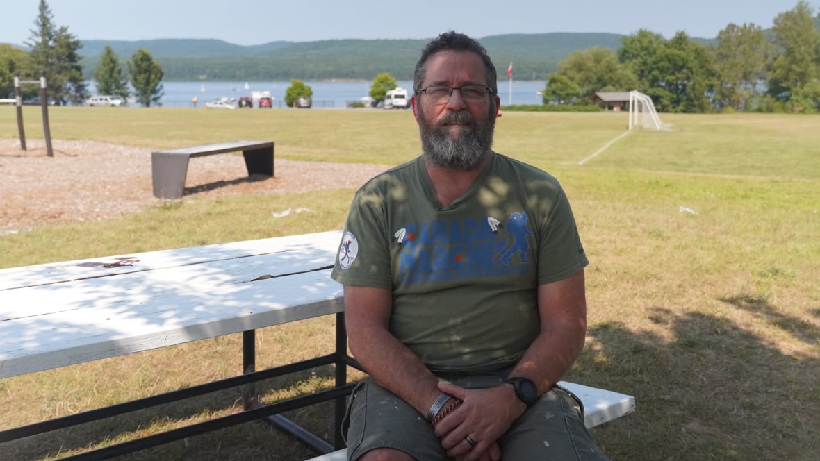 A man sits on a park bench.