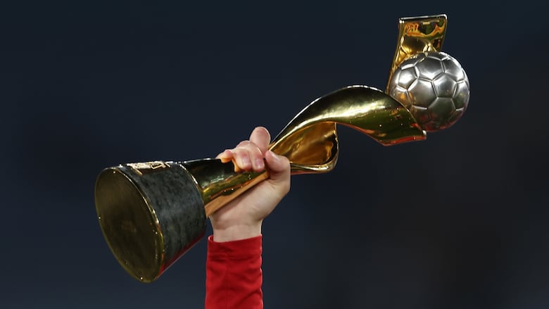 A trophy is held aloft.