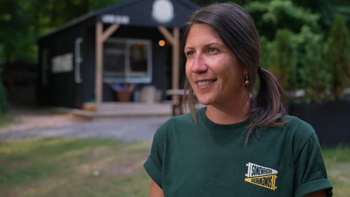 A white woman in a green tee shirt.