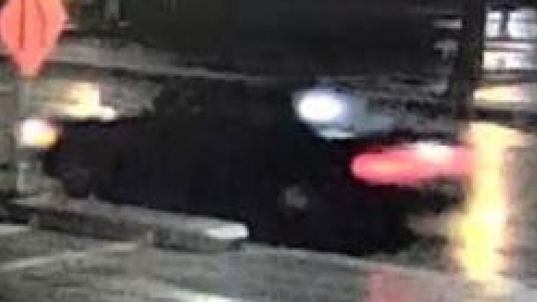A black car is seen on a grainy image. 