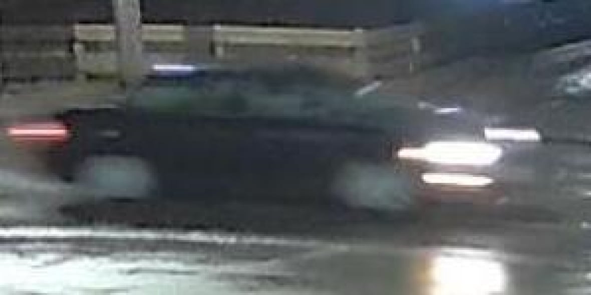 A black car is seen on a grainy image.