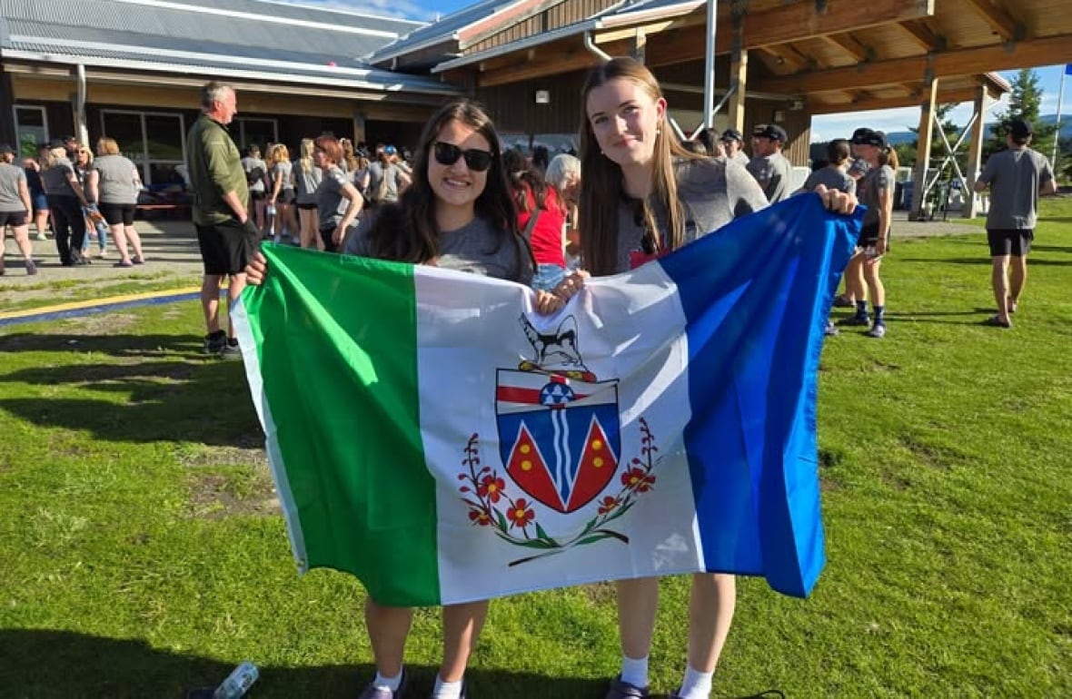 Two young girls holding a Yukon flag.