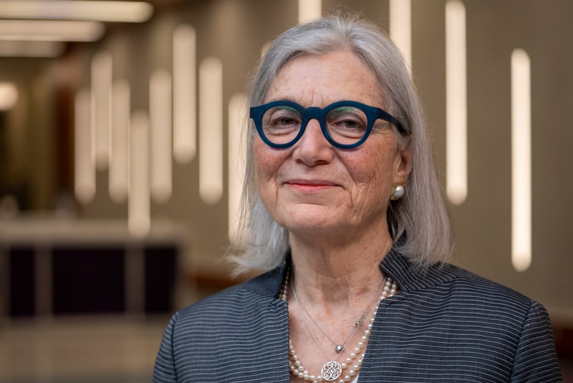 Extra ladies get Alzheimer's than males. It could not simply be as a result of they reside longer 1 A woman with a grey bob and thick blue glasses smiles at the camera. She is wearing pearls and a grey-black blazer