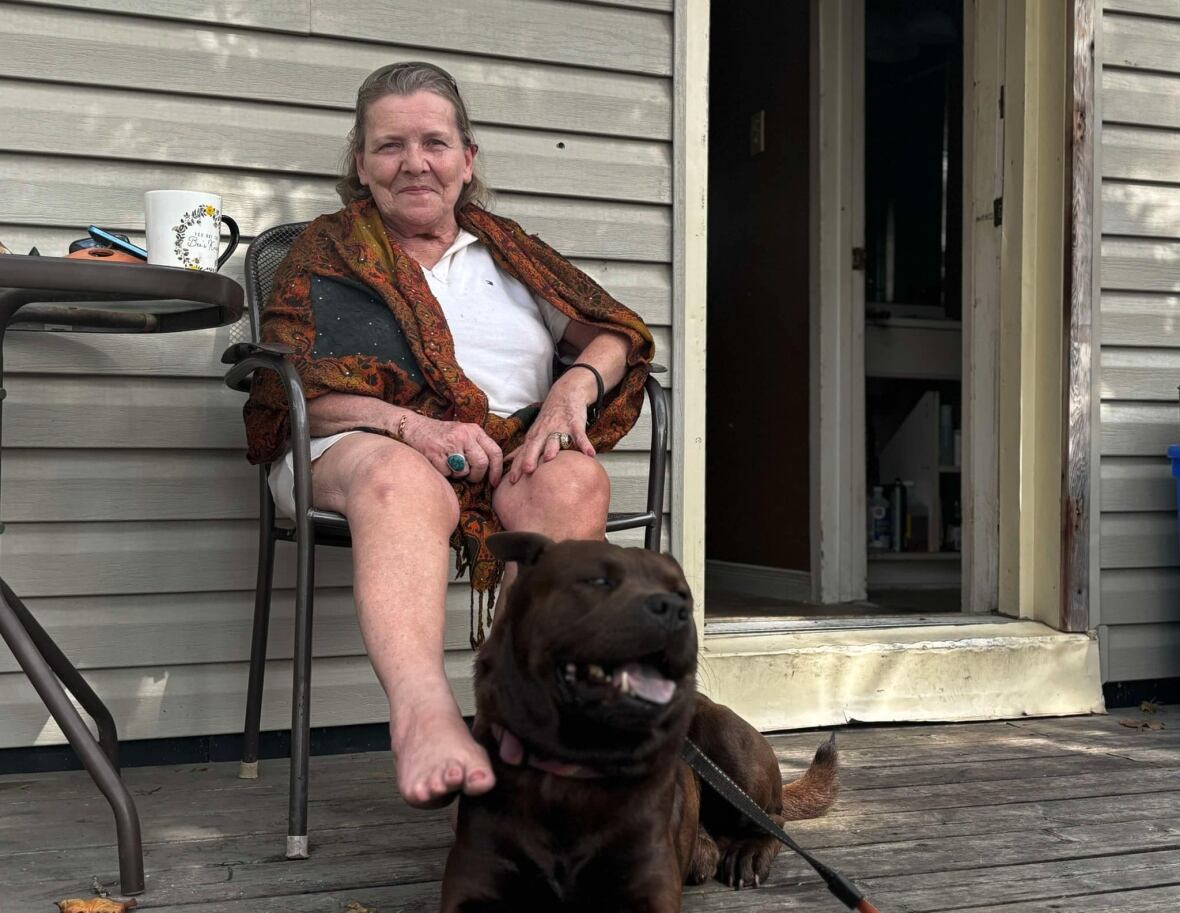 A woman sits with a dog