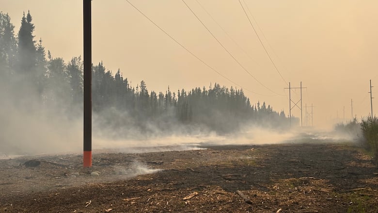 Smoke rises from a patch of burned ground.