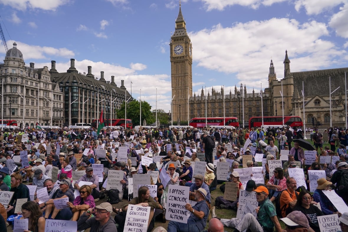 The demonstrators carry signs while sitting in public places.