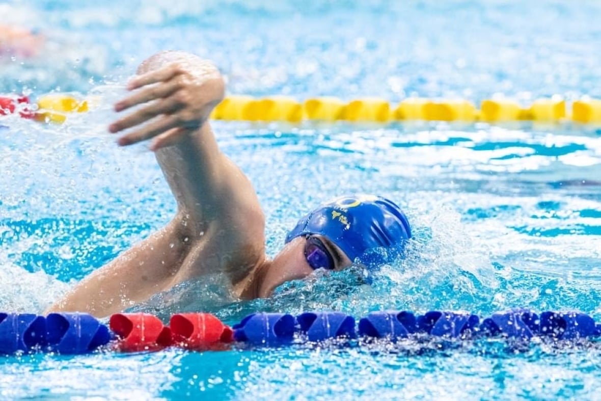 A man is seen swimming in a pool.