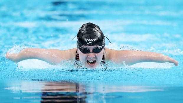 A female Paralympic swimmer representing Canada competes in a butterfly event.