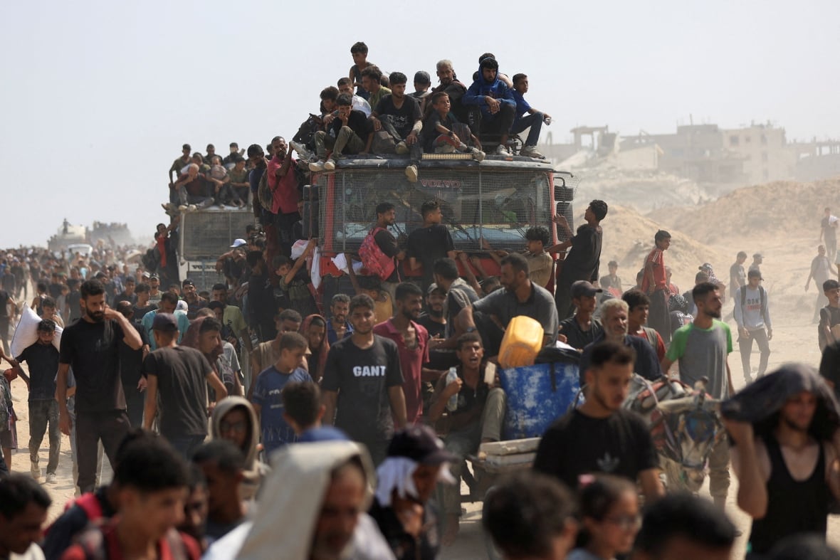 People sit on top and walk along with auxiliary trucks.