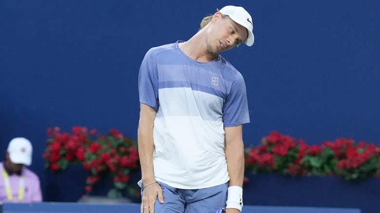 A men's tennis player reacts during a match.