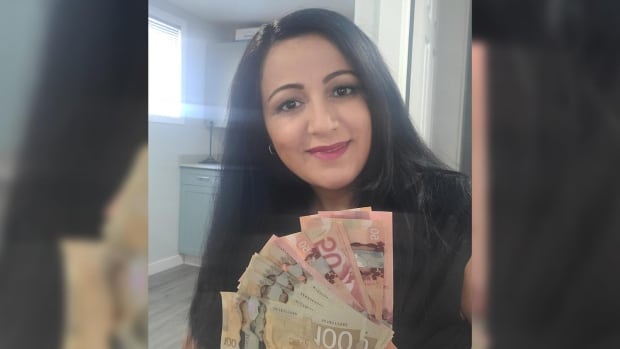 Annie Rawdah holds $1,000 she found at a drive-thru ATM
