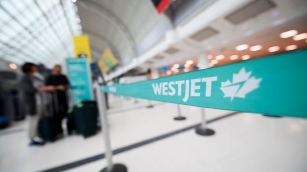 Image shows a WestJet line divider at the airport