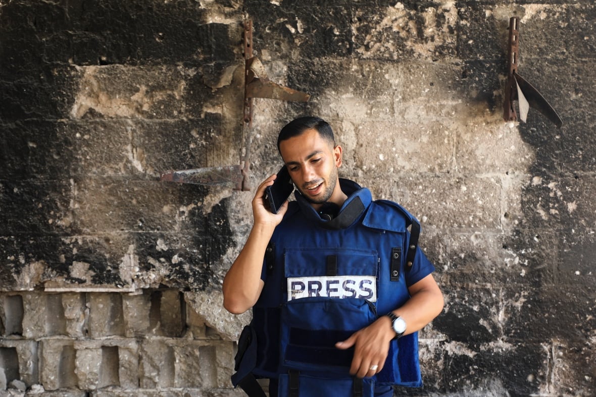 Al Jazeera journalist Anas Al Sharif, who was killed in an Israeli strike on August 10, 2025, speaks on the phone in Gaza City August 13, 2024. 