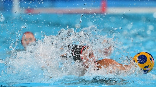 Women's players compete in a water polo match.