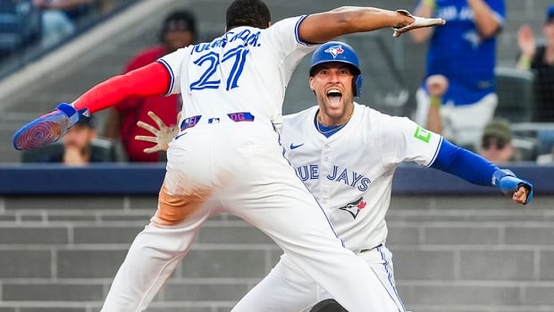 Toronto Blue Jays outfielder George Springer celebrates with first baseman Vladimir Guerrero Jr. while on both knees in a July 21, 2025 MLB regular-season game against the visiting New York Yankees.