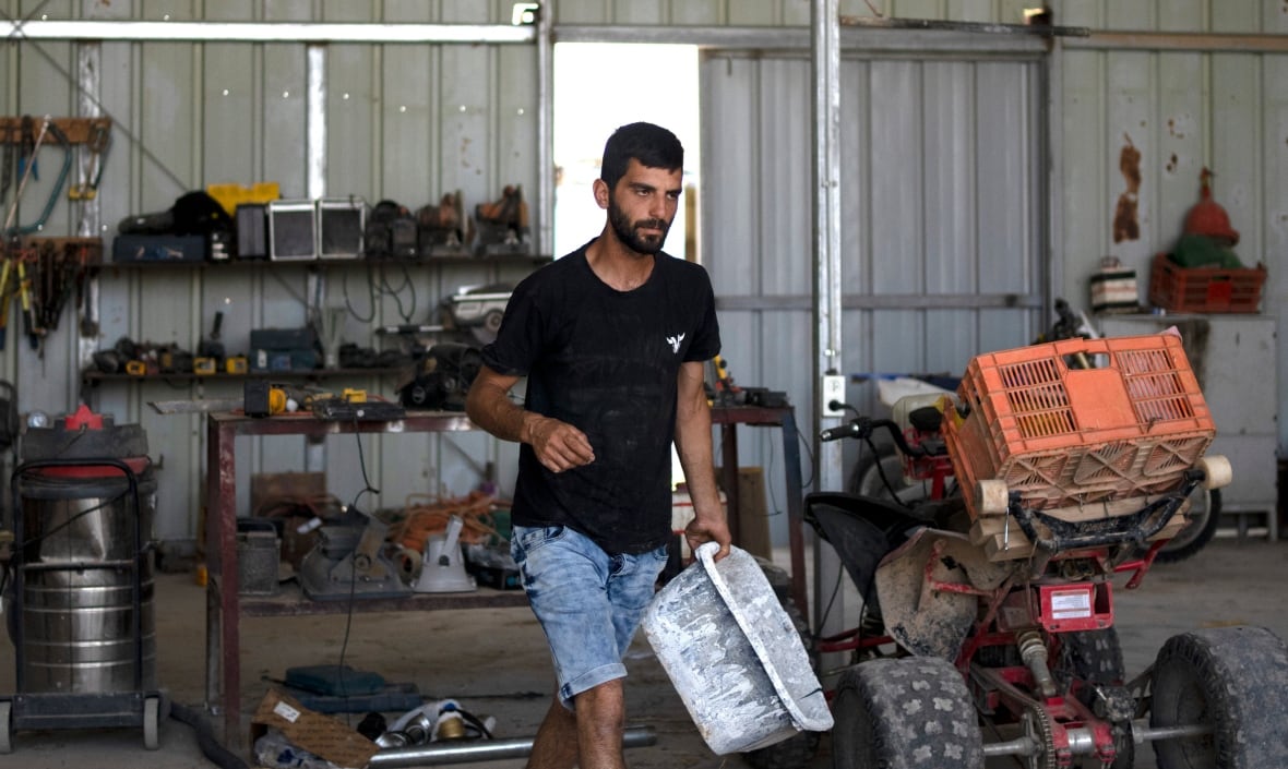 Someone works in the field in black t-shirt and in the chests of Dam checks.