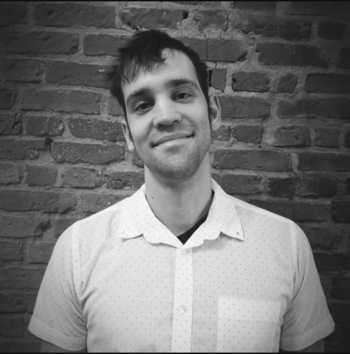 Man in short sleeve shirt smiles.