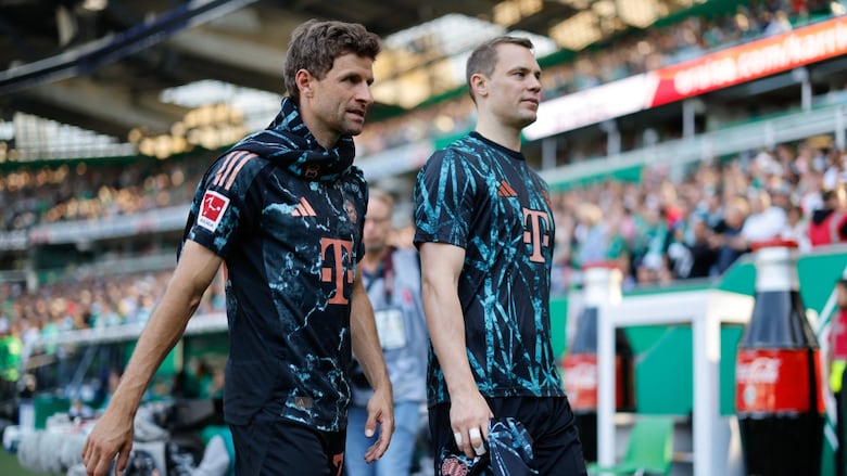 Two soccer players walk off the pitch.