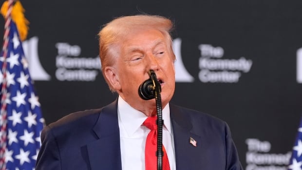 President Donald Trump speaks at the Kennedy Center, Wednesday in Washington, D.C., announced honorees he said that he was heavily involved with selecting. A cleanshaven older man in suit and tie speaks at a podium with American flags behind him.