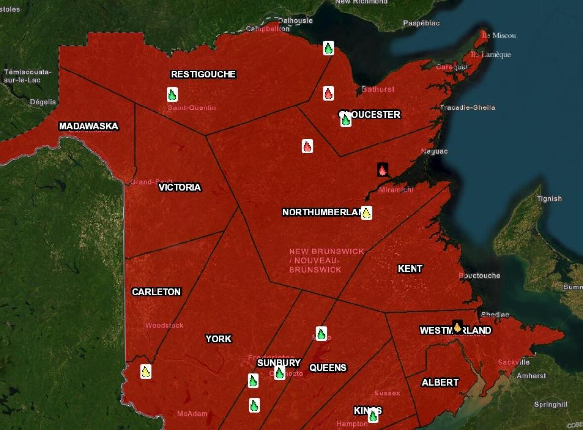 A map of New Brunswick coloured red with small fire icons scattered on it. Three red icons are centralized in the north east.