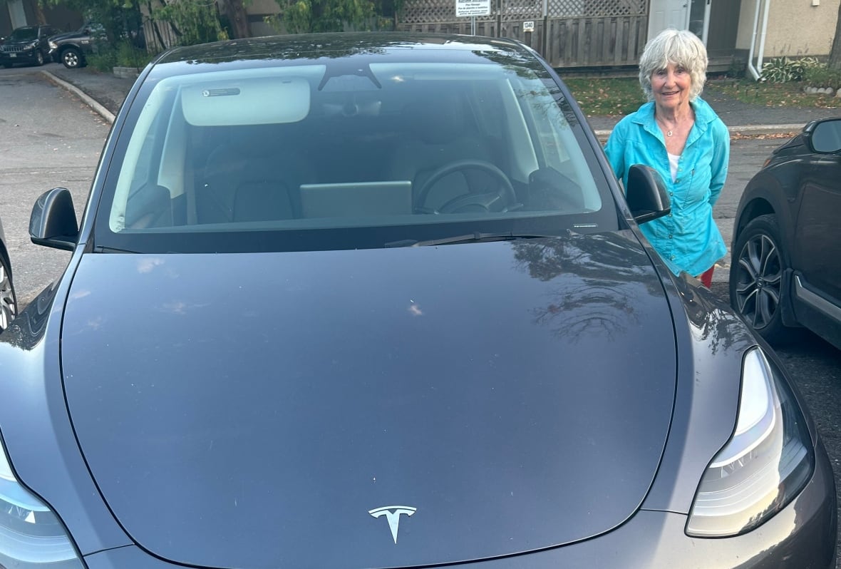 Woman beside Tesla car viewed from the front
