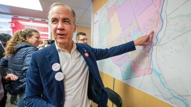 Liberal Leader Mark Carney looks over a map of his riding at his campaign office in Nepean, ON on Saturday March 29, 2025. THE CANADIAN PRESS/Frank Gunn A man points at a map.