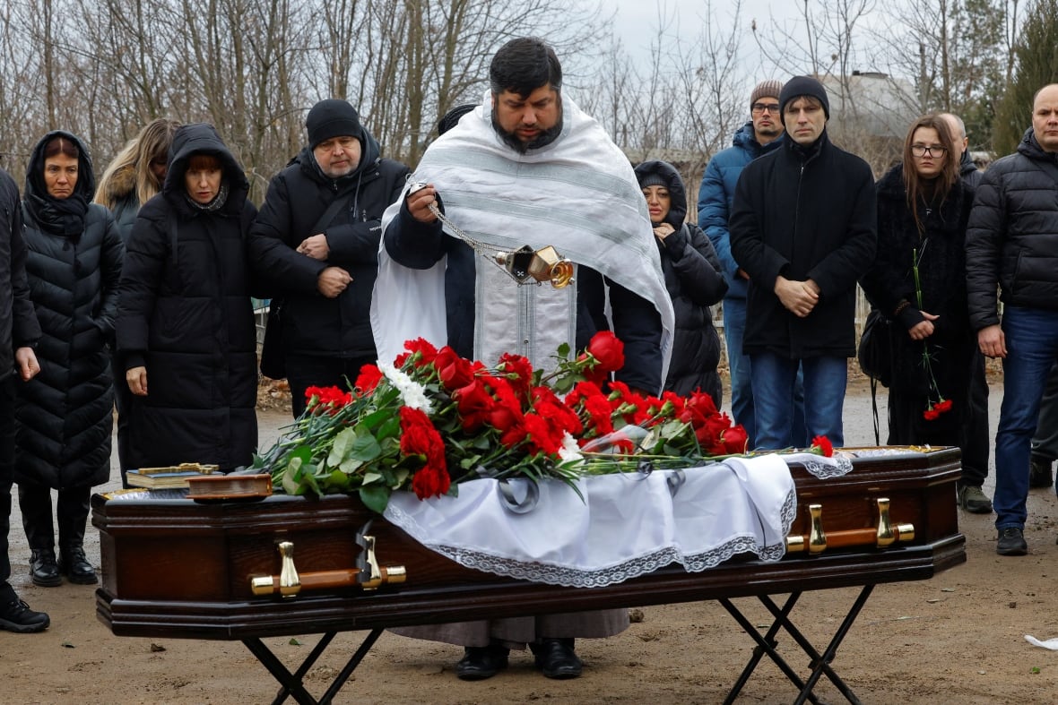 A priest performs a service during the funeral of Alexander Martmanov, an independent Russian media correspondent, Izvestia, who was killed in a drone on a highway while traveling by car from Hormelvka to Donetsk, January 8, 2025. 