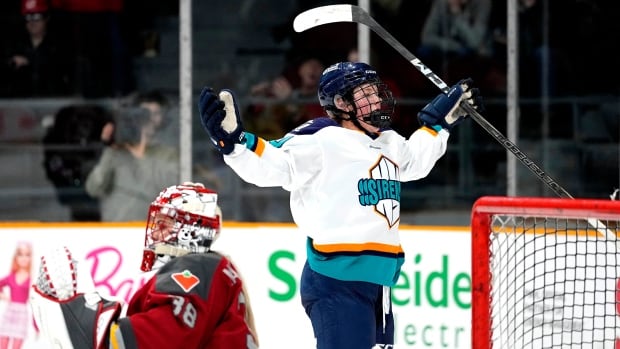 A hockey player wearing a New York Sirens jersey celebrates on the ice.