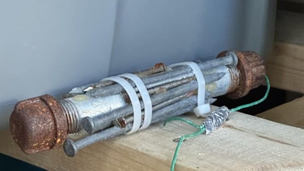 An image of the improvised explosive device, or pipe bomb, submitted by Sgt. Mike Wicentowich of the Trail RCMP. A five-inch metal device wrapped with nails with a fuse on the end.