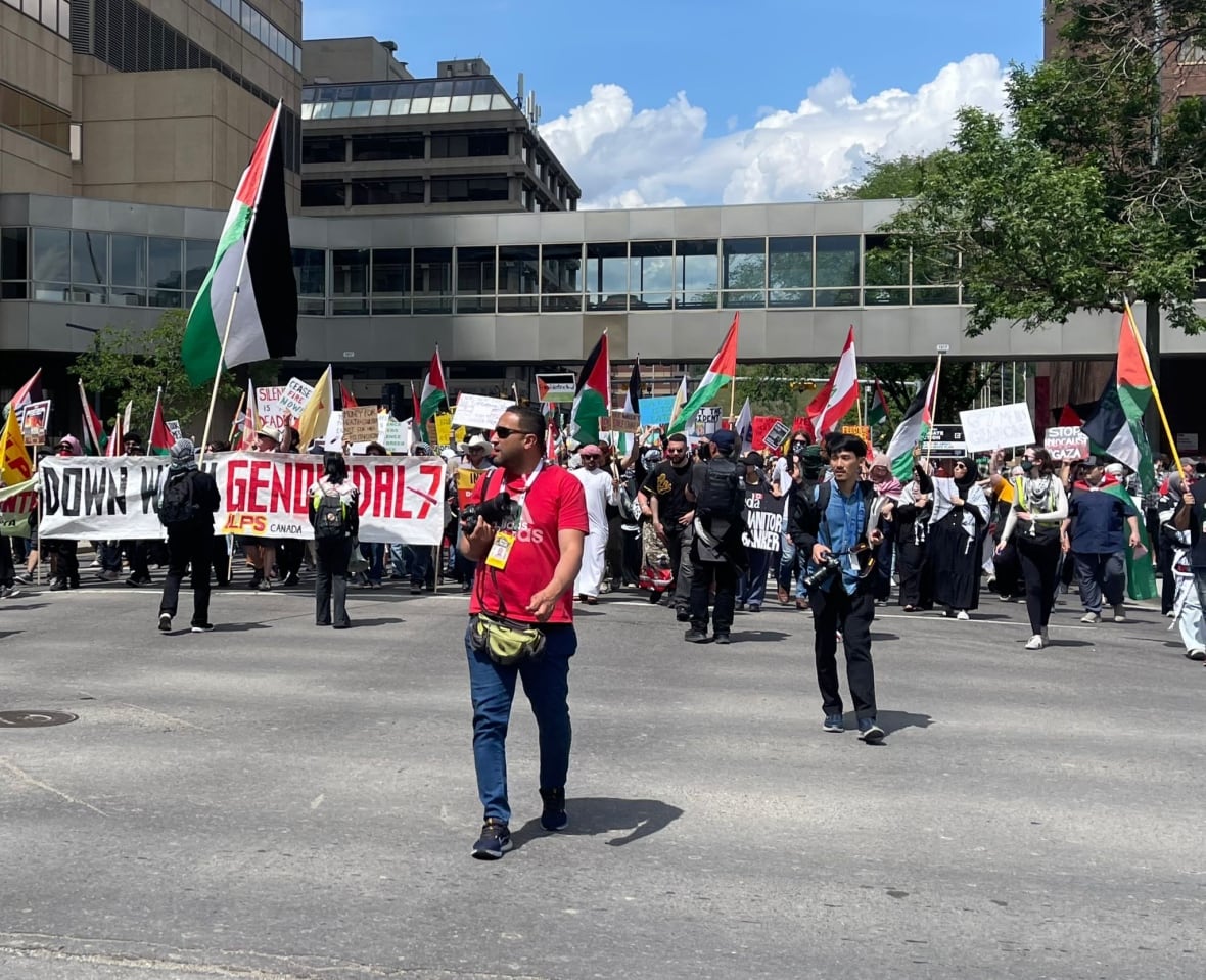 Photographer stands in front of a pro-Palestinian protest.