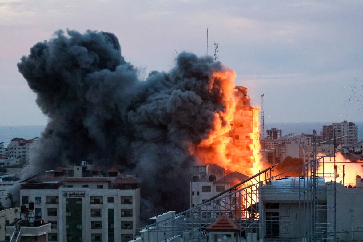 Smoke and flames billow after Israeli forces struck a high-rise tower in Gaza City, October 7, 2023. 