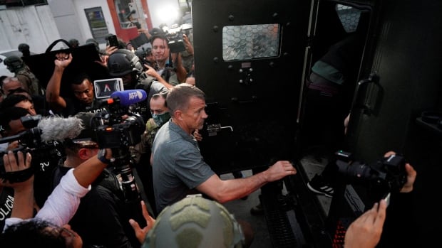 A photo showing Erik Prince climbing into an armoured personnel carrier, during a police and military presentation in Ecuador in April 2025.