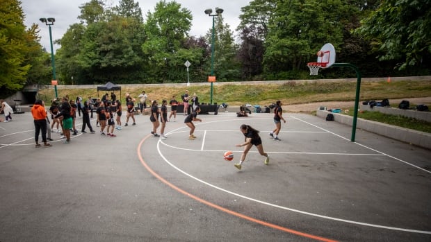 Young girls play on a basketball court at Stanley Park. 