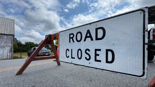 A barricade is set up with a sign that says Road Closed.