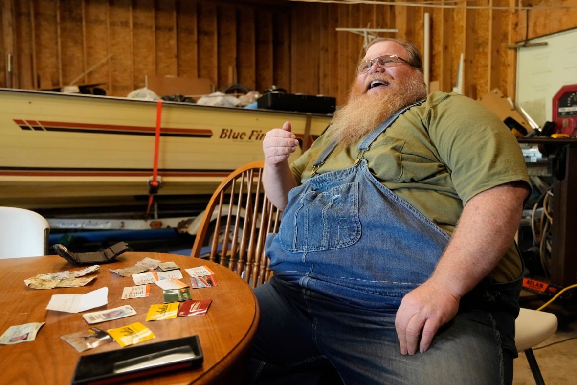 Richard Guilford speaks in an interview in front of items found in his lost wallet Thursday, Aug. 14, 2025, in Petersburg, Mich.